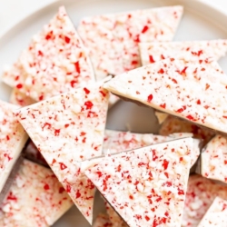 Chunks of salted peppermint bark on a white serving platter.