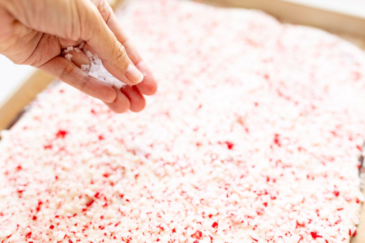 Peppermint bark covered in crushed peppermint on a baking sheet