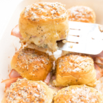Hot ham and cheese sliders in a baking dish.