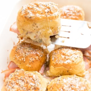 Hot ham and cheese sliders in a baking dish.