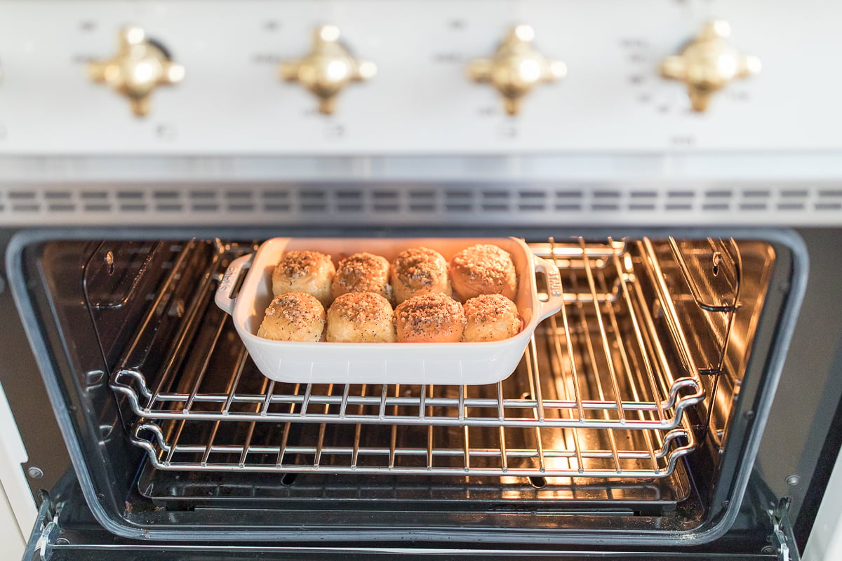 A tray of hot ham and cheese sliders in an oven.