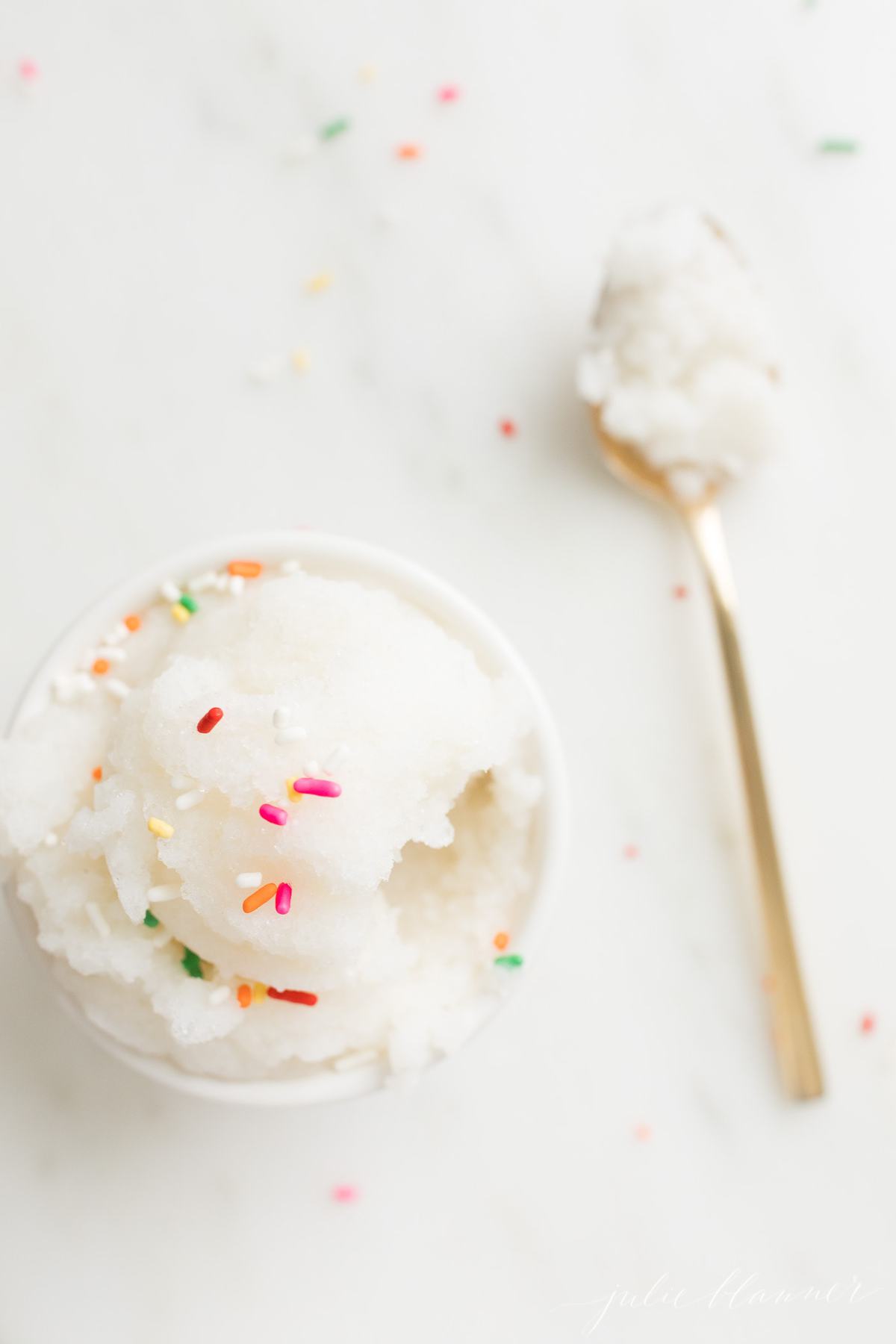 snow ice cream in a bowl with gold spoon next to it