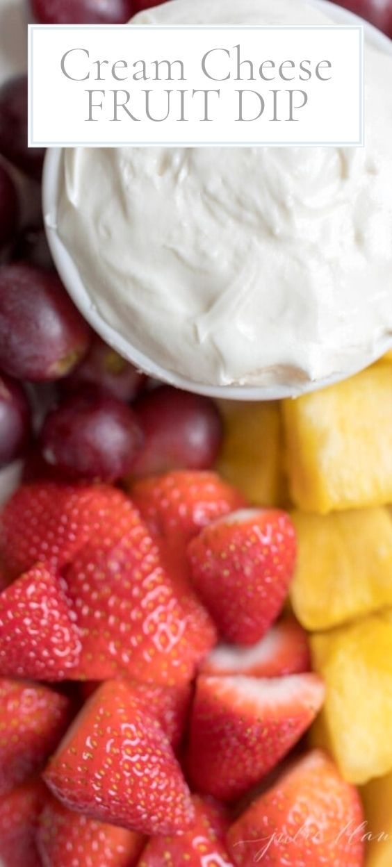 white tray holding cream cheese dip and fresh fruits.