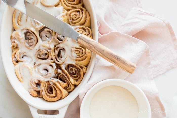 cinnamon roll glaze poured over cinnamon rolls