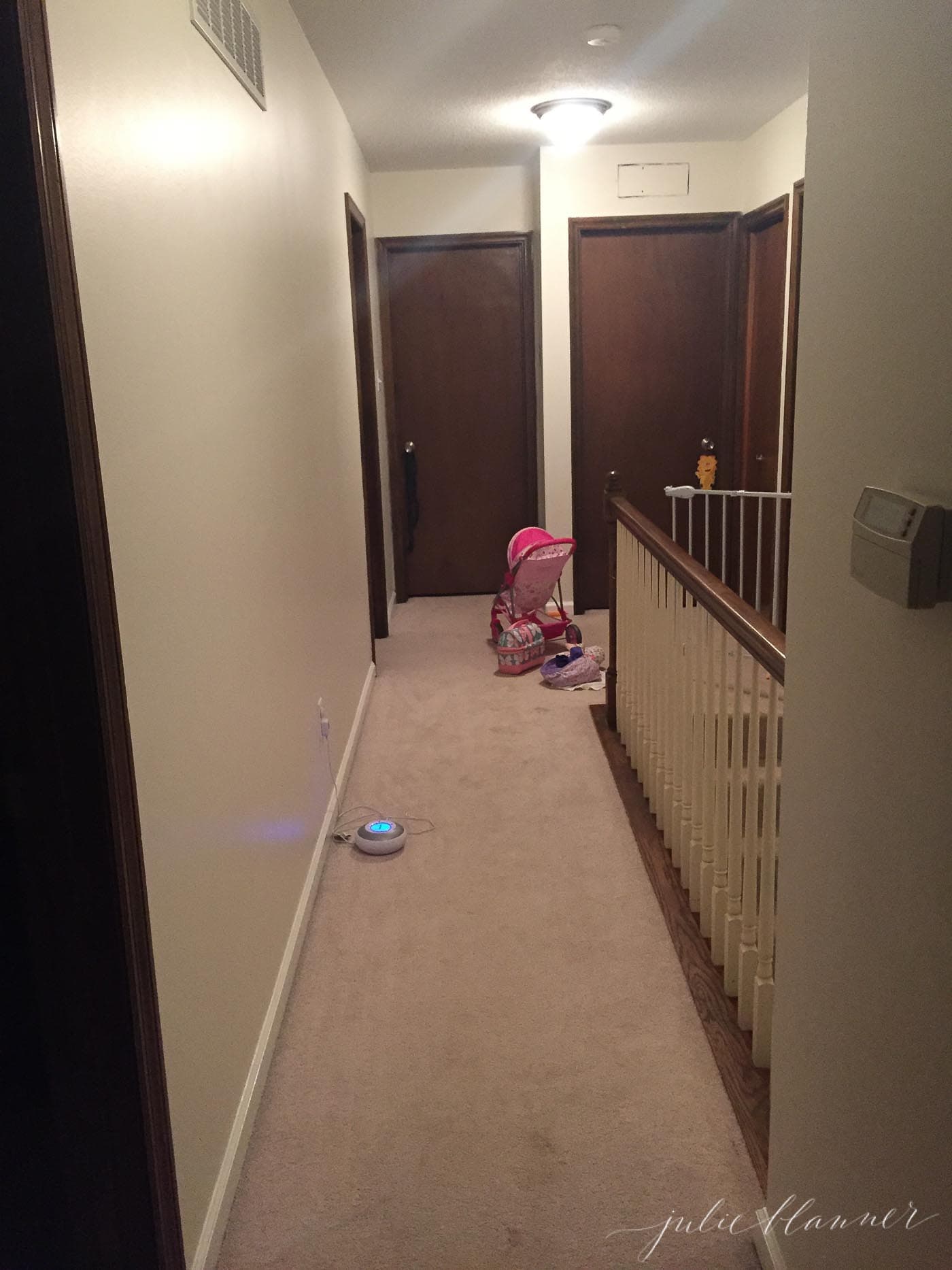 dated and dark hallway in a vintage home, carpeted floors and dark doors