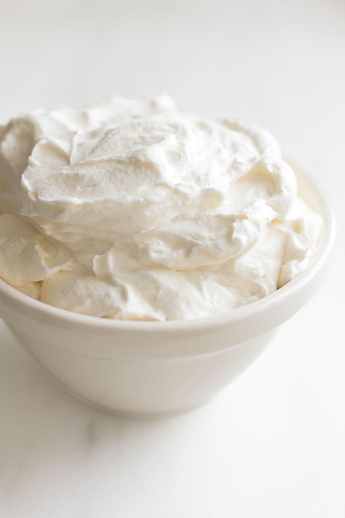 A white bowl full of homemade whipped cream.