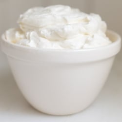 A white bowl full of homemade whipped cream.