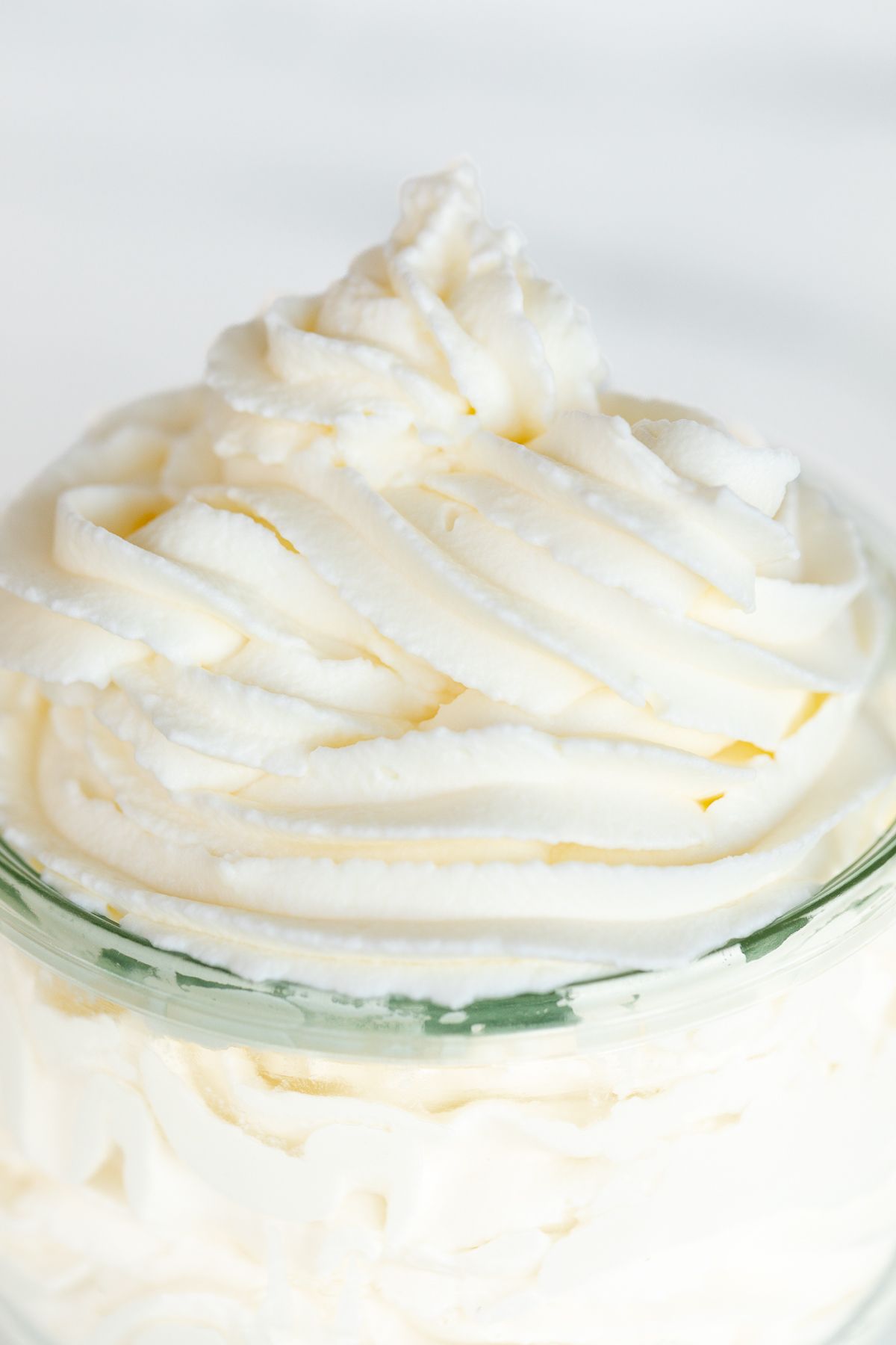 A small glass jar full of homemade whipped cream.