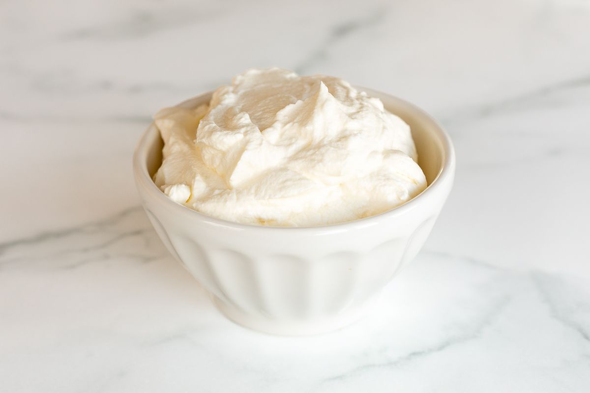 A white bowl full of homemade whipped cream.