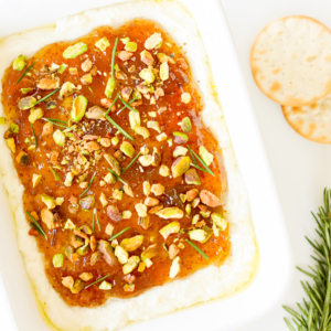 A white dish with pistachio goat cheese spread.