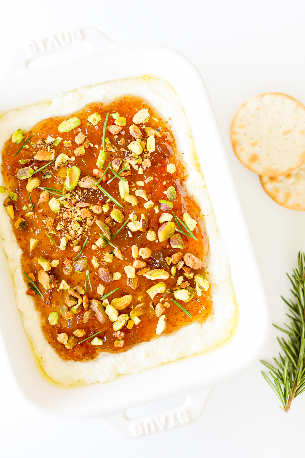 A white dish with pistachio goat cheese spread.
