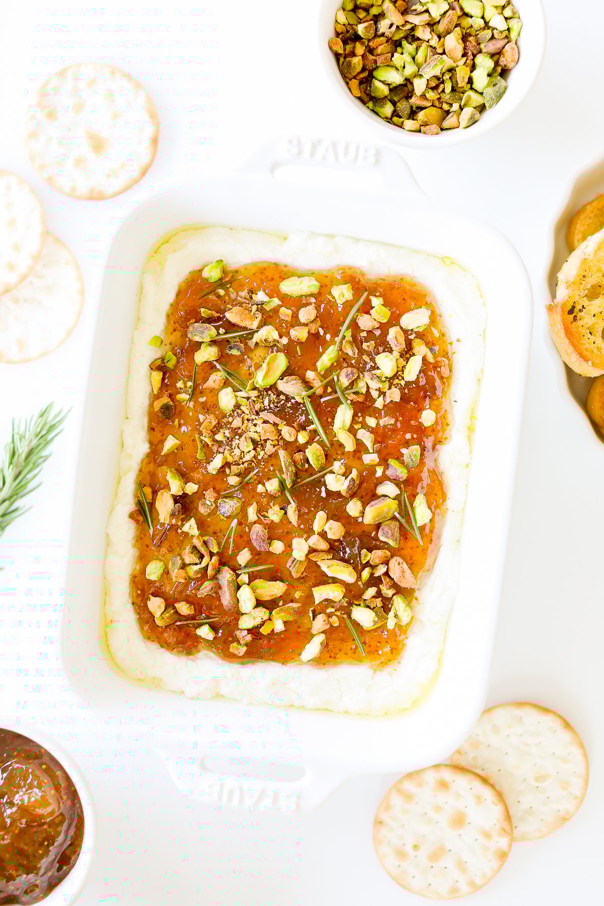A white dish with pistachio goat cheese spread.