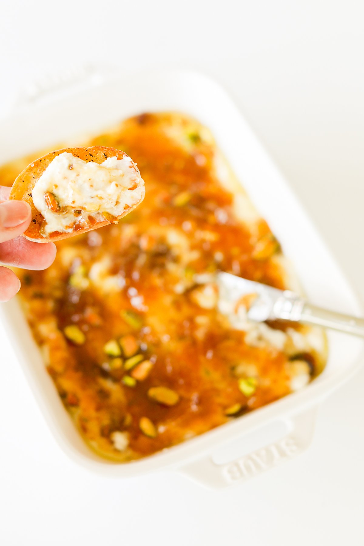 A white dish with pistachio goat cheese spread.