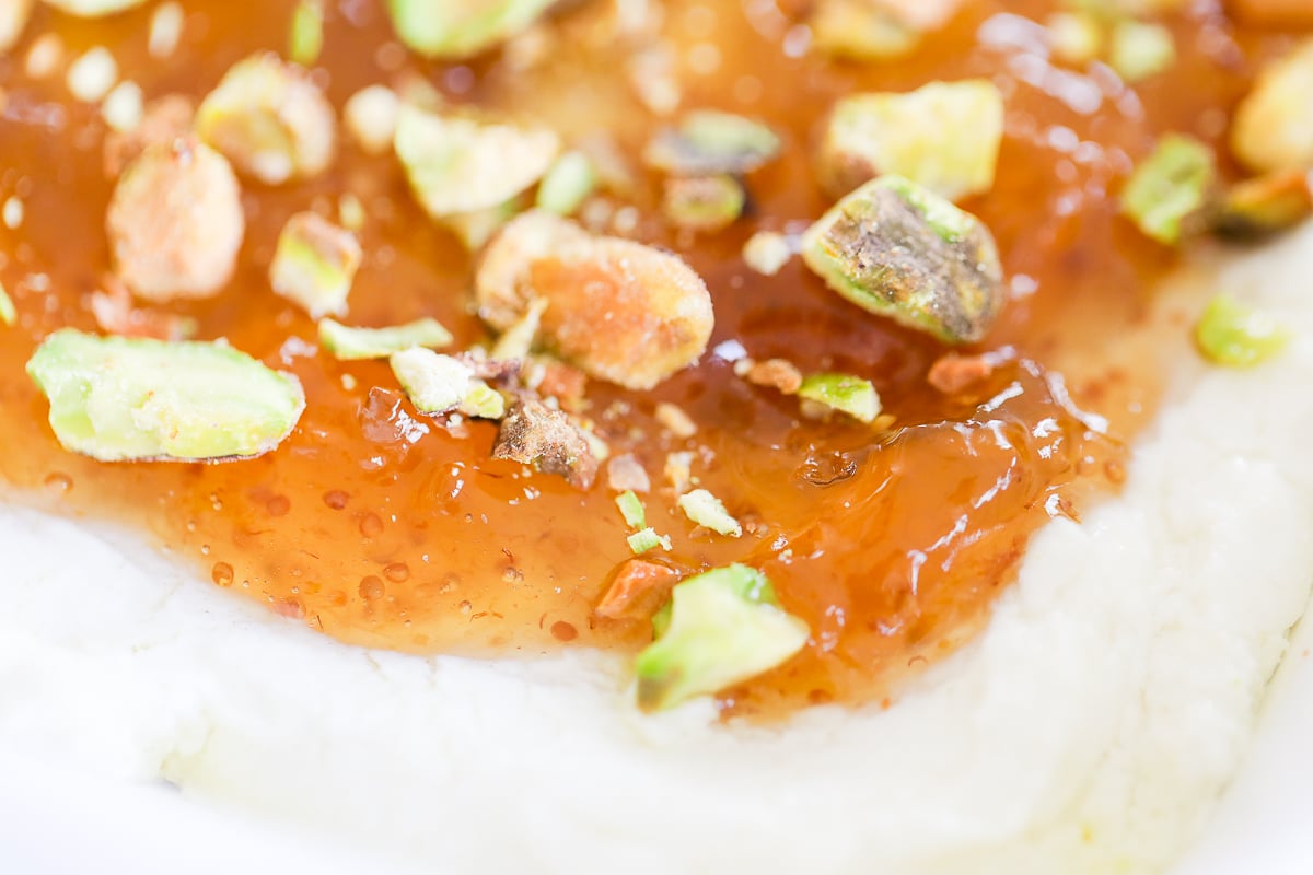 A white dish with pistachio goat cheese spread.