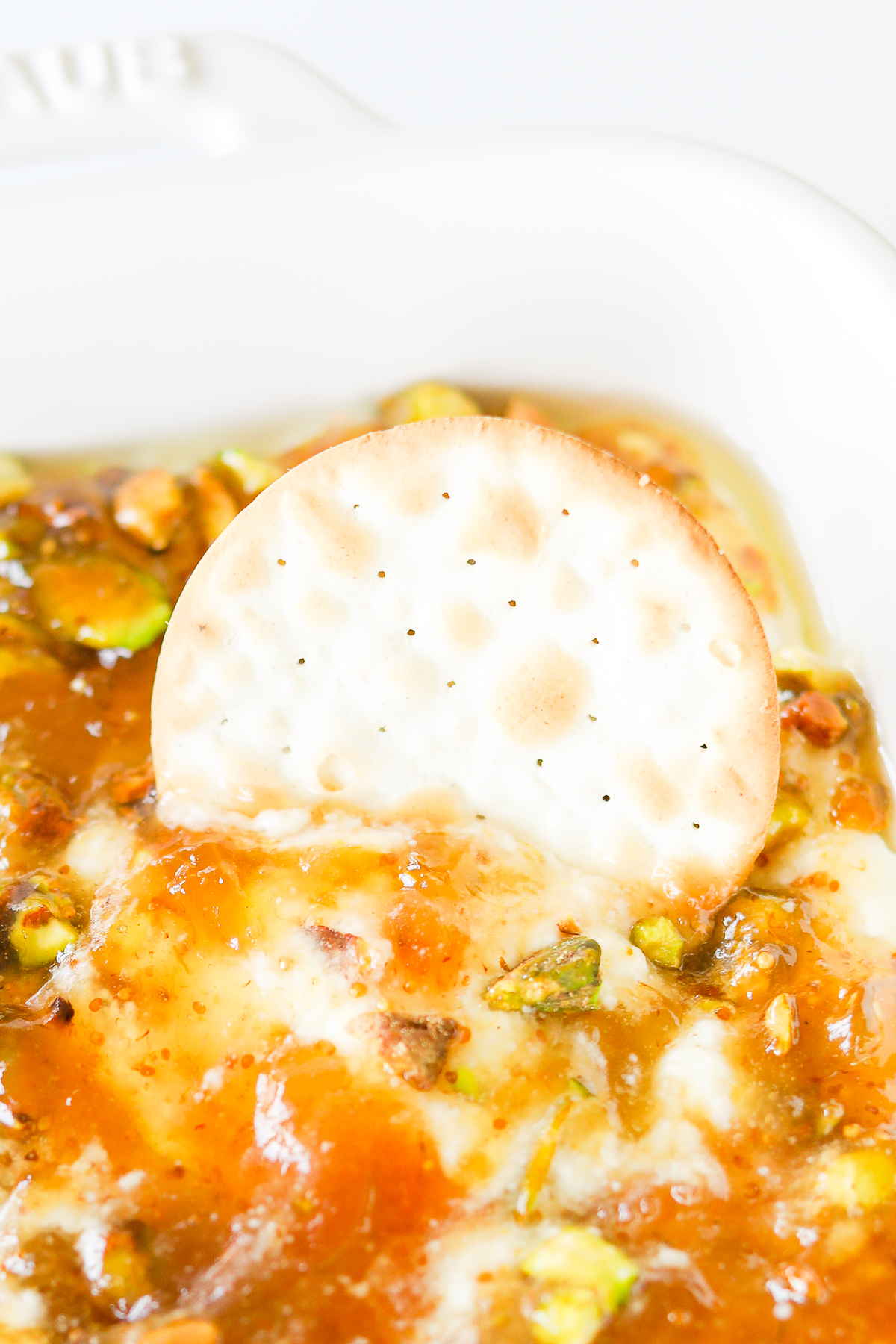A white dish with a cracker on top of it.