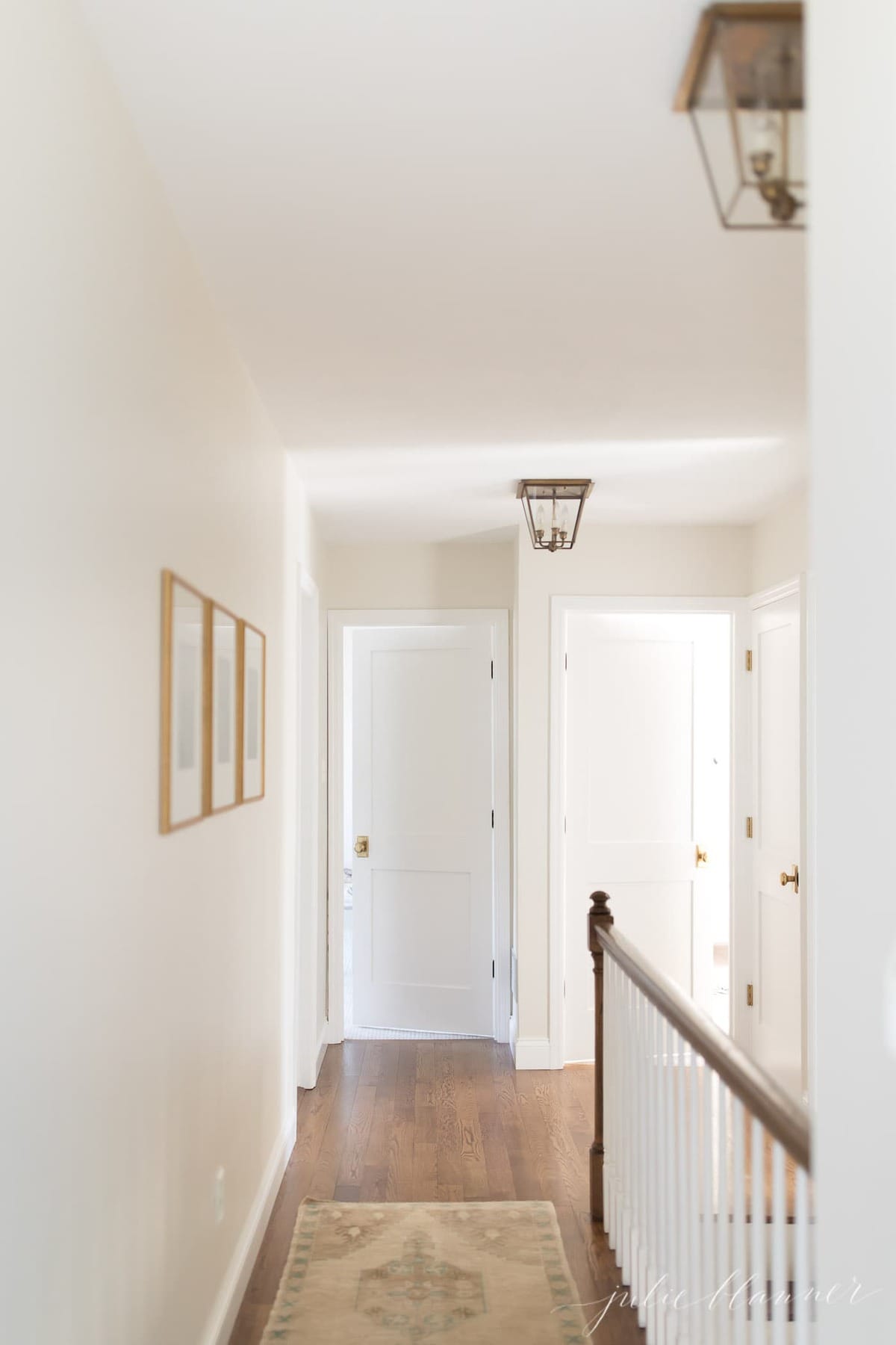 A white painted upstairs hallway with lots of doors in a vintage home