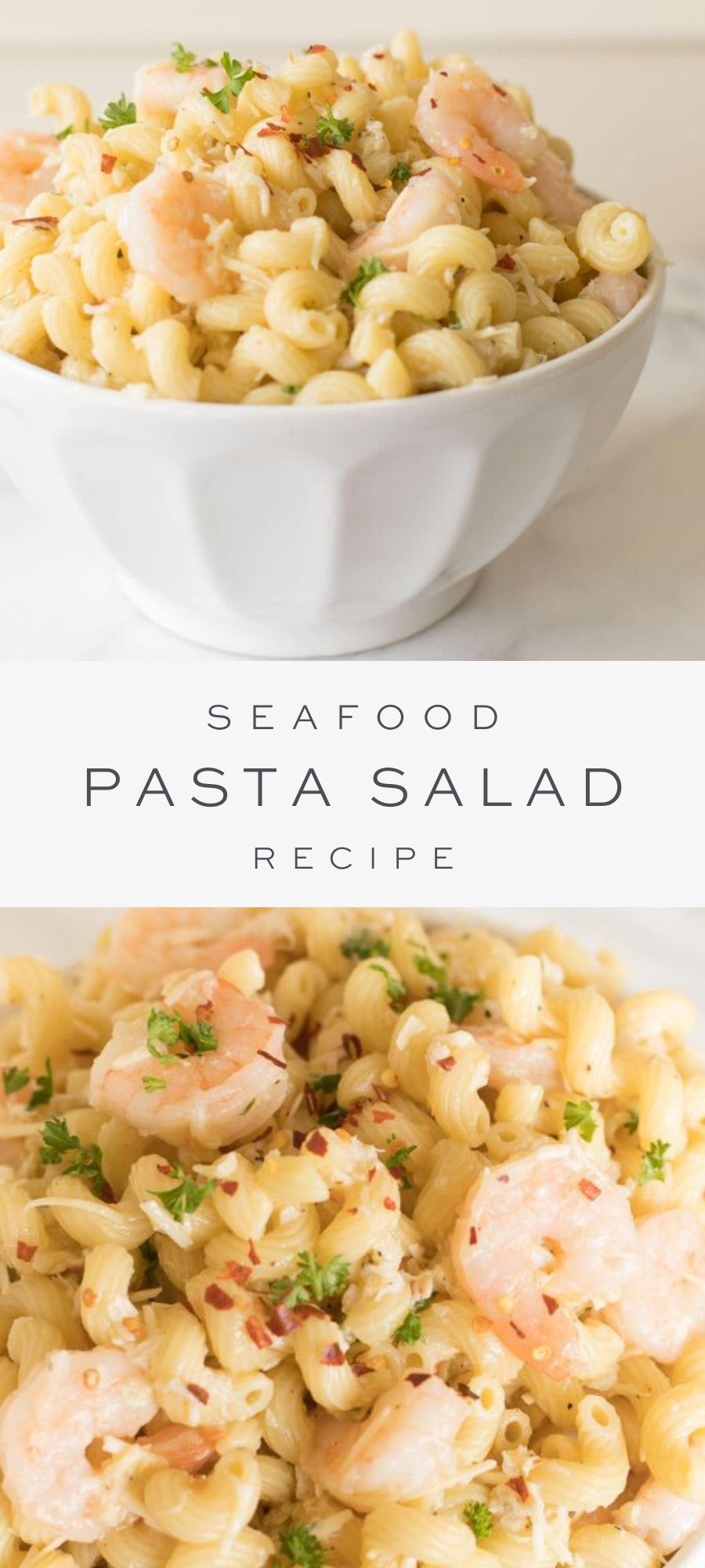 On a marble counter top, there is a round white bowl of seafood pasta salad.