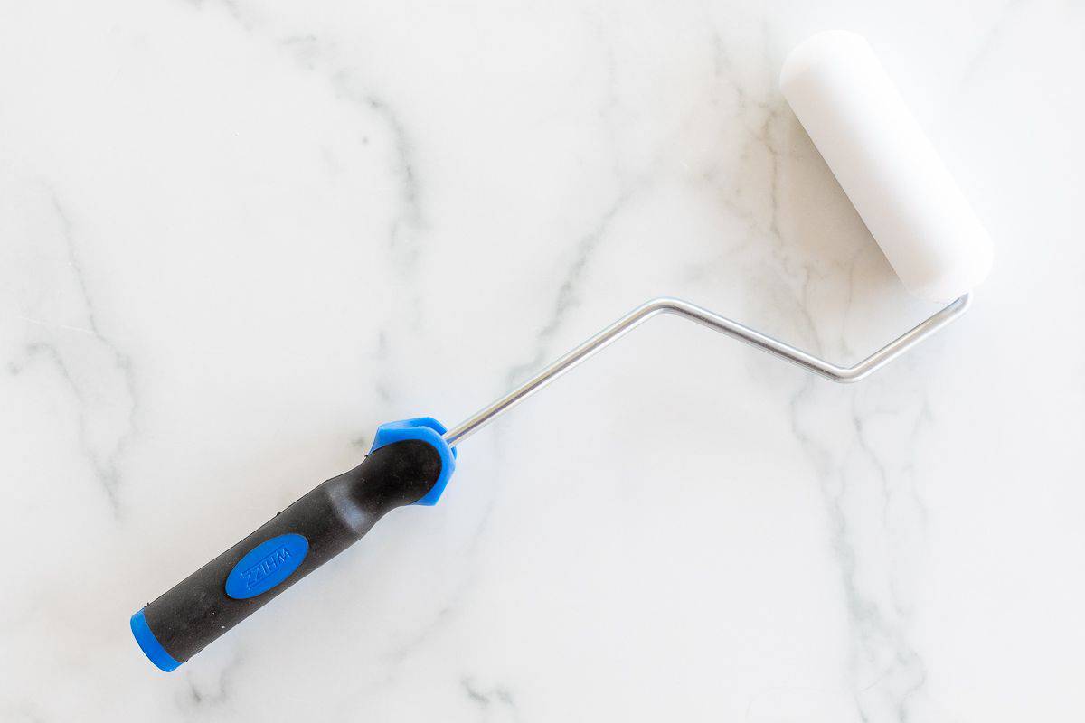 A foam paint roller on a marble surface.