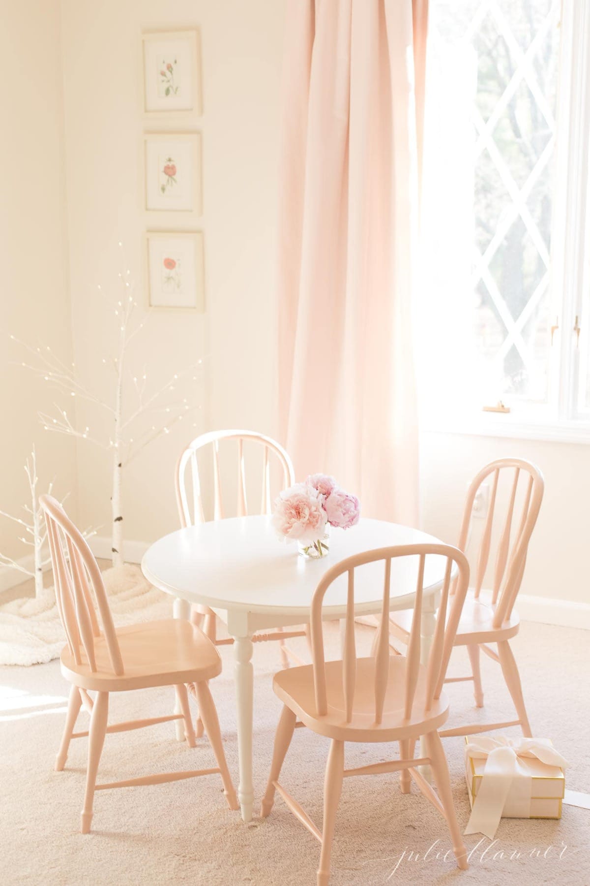 A white little girl's bedroom with a small round table and chairs painted in fresh furniture paint.