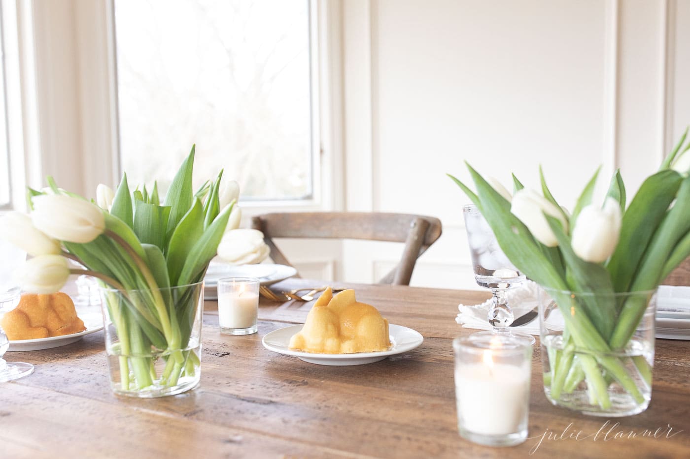 mini easter cake on dessert plates by tulips