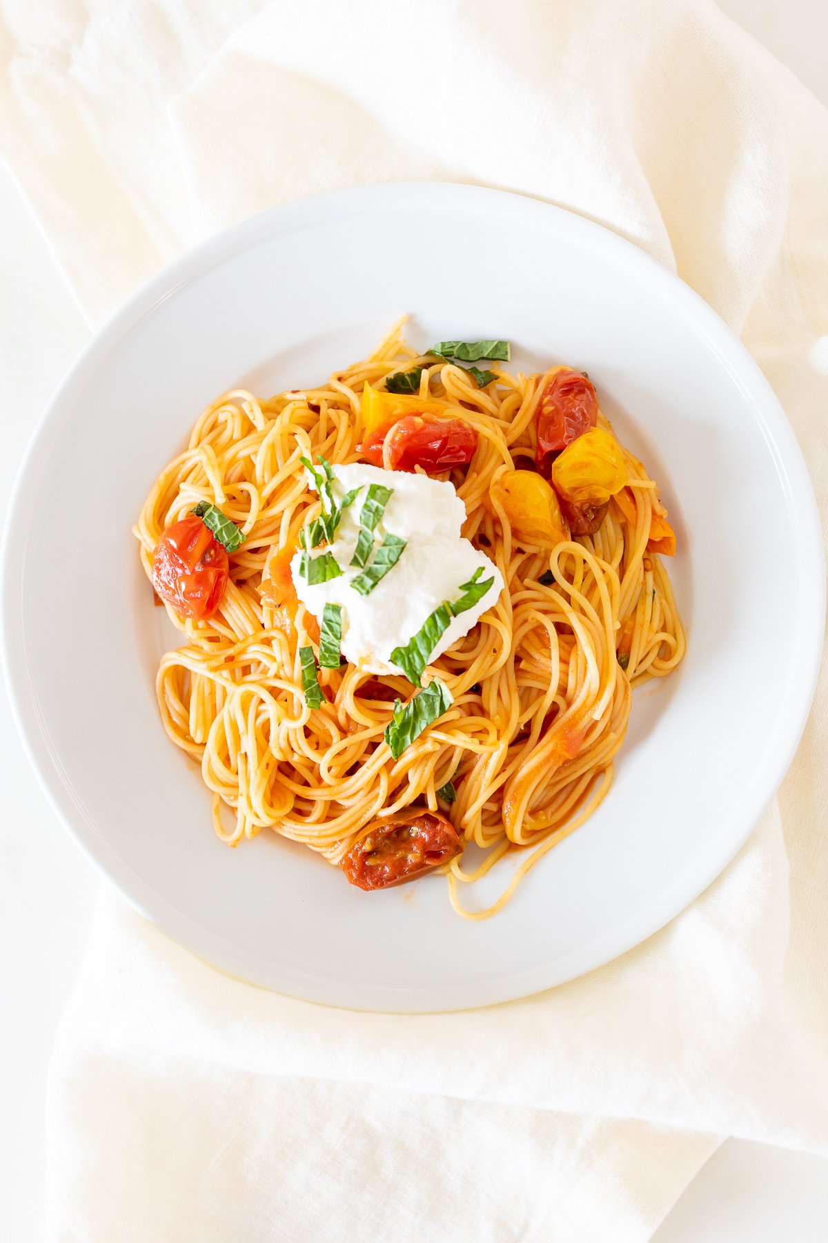 cherry tomato pasta on a white plate.