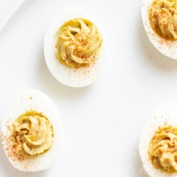 Avocado deviled eggs on a white platter.