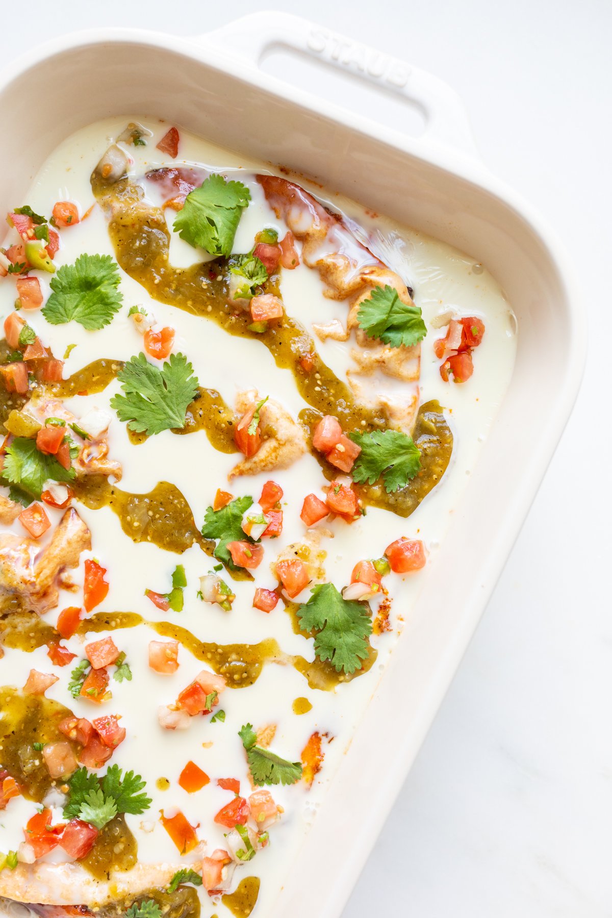 Chorizo burrito Mexican breakfast casserole in a white baking dish. 