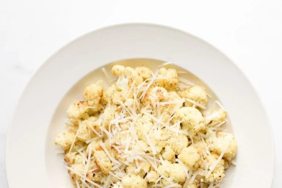 fiesta ranch roasted cauliflower on a white plate, topped with grated parmesan cheese.