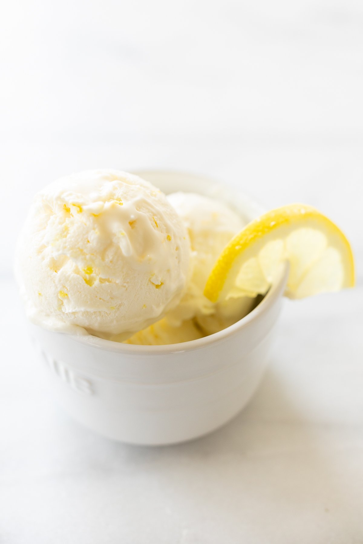 A white bowl full of homemade no churn lemon ice cream.