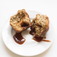 Caramel and Banana Muffin split in half on a white plate.