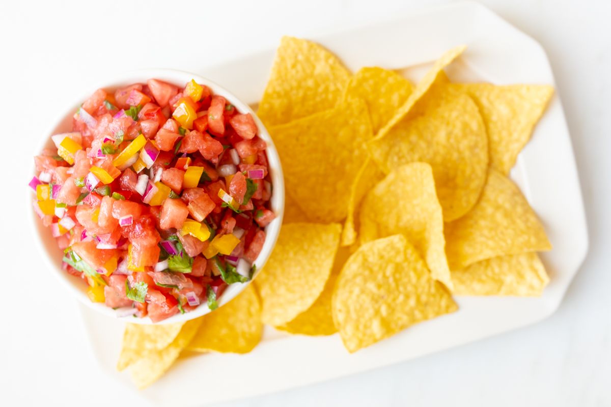 A platter of tortilla chips with a bowl of fresh watermelon salsa.