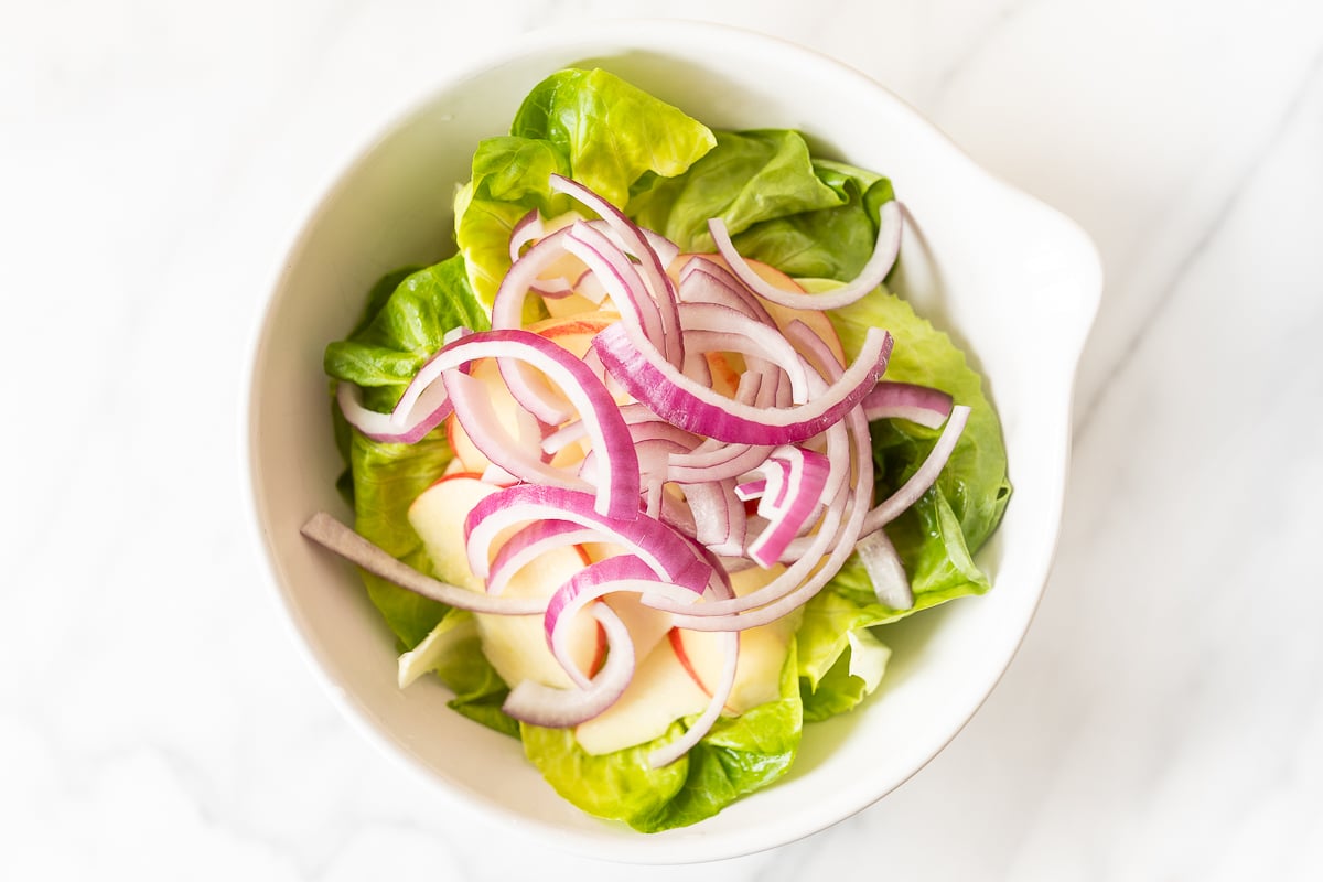 A white bowl full of homemade apple salad.