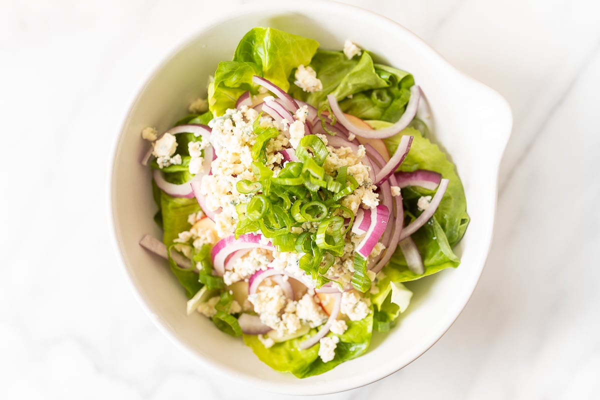 A white bowl full of homemade apple salad.