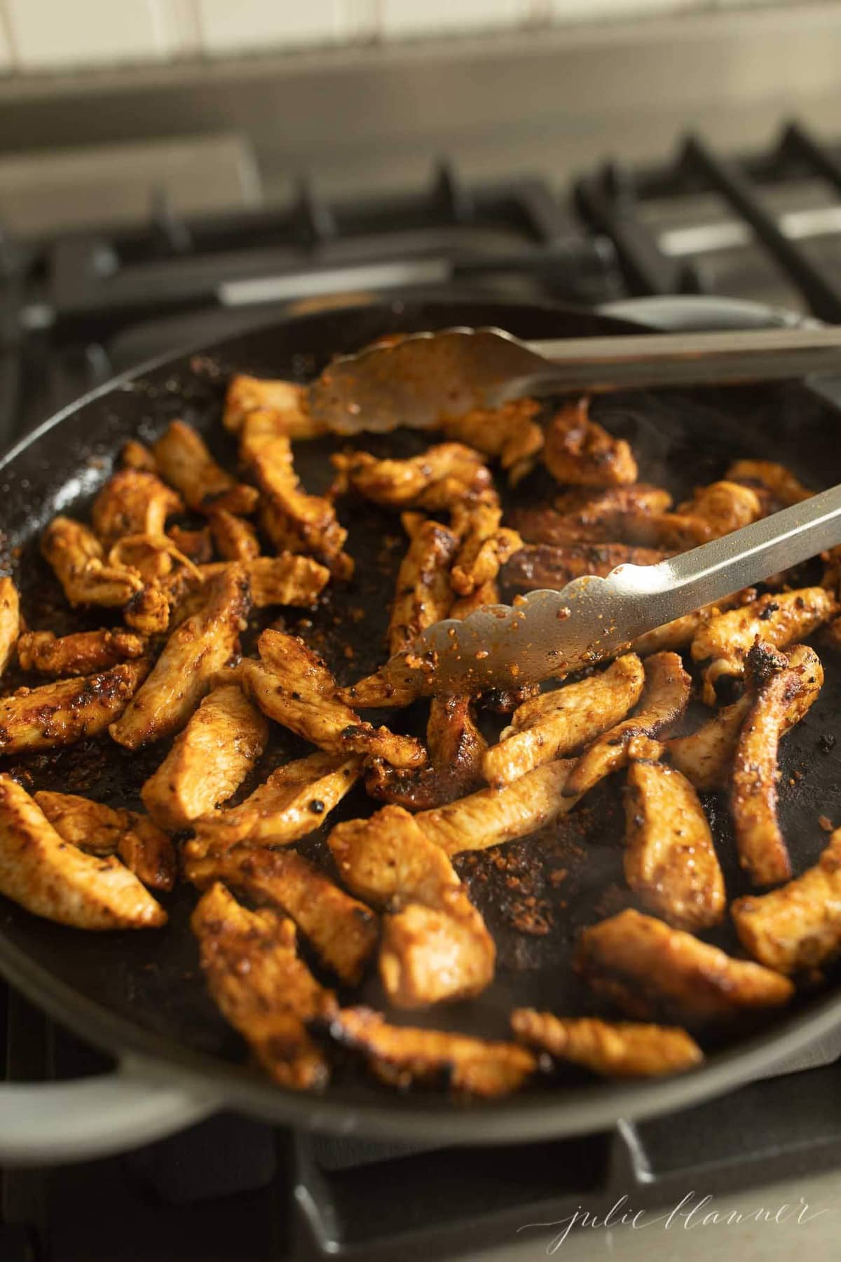 cajun chicken seasoning on chicken in a cast iron skillet