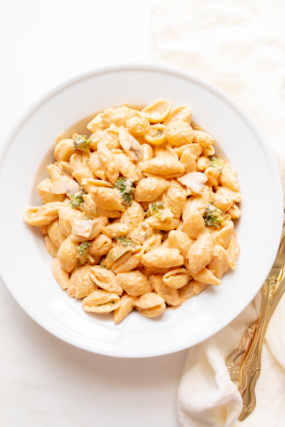 A white plate of pasta con broccoli.