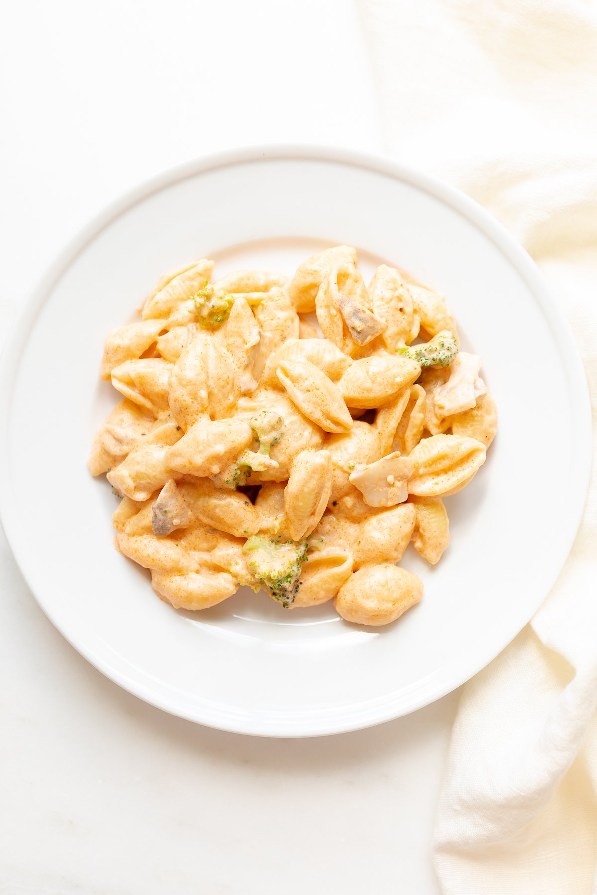 A white plate of pasta con broccoli.