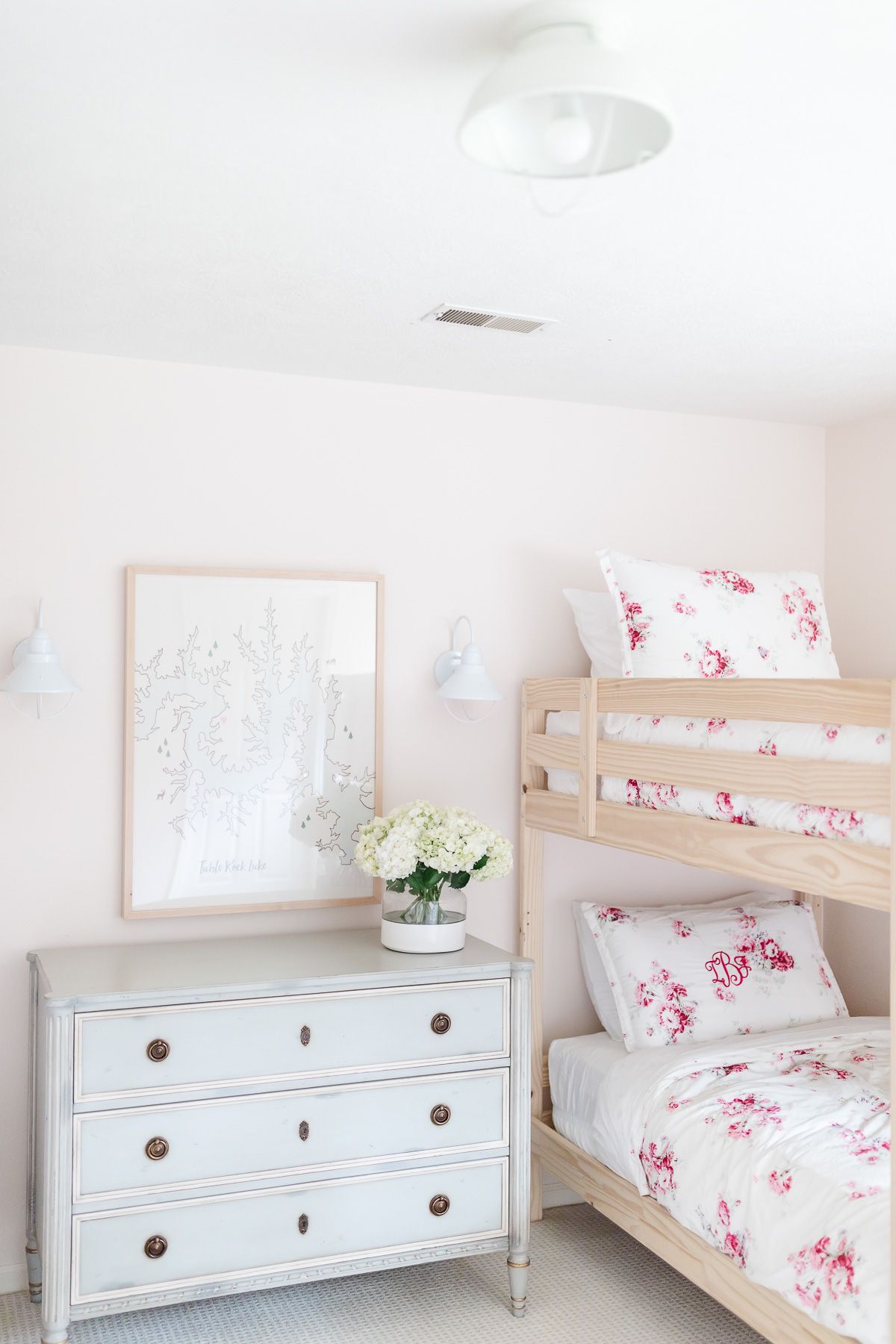 A bunk bedroom with pale pink walls and white ceiling paint.