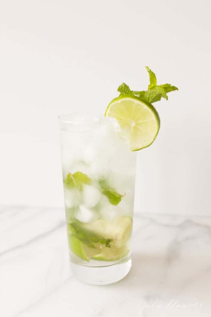 mojito in a tall glass with lime and mint