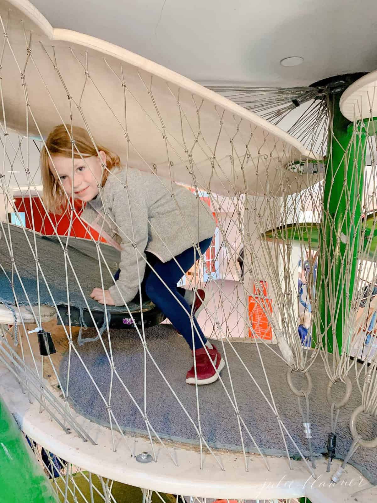 Little girl playing inside an indoor children's playground.