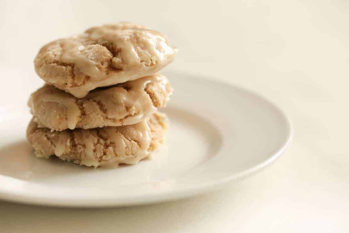 Stack of three apple pie cookies with an apple glaze, on a white plate. #appleglaze #appleciderglaze