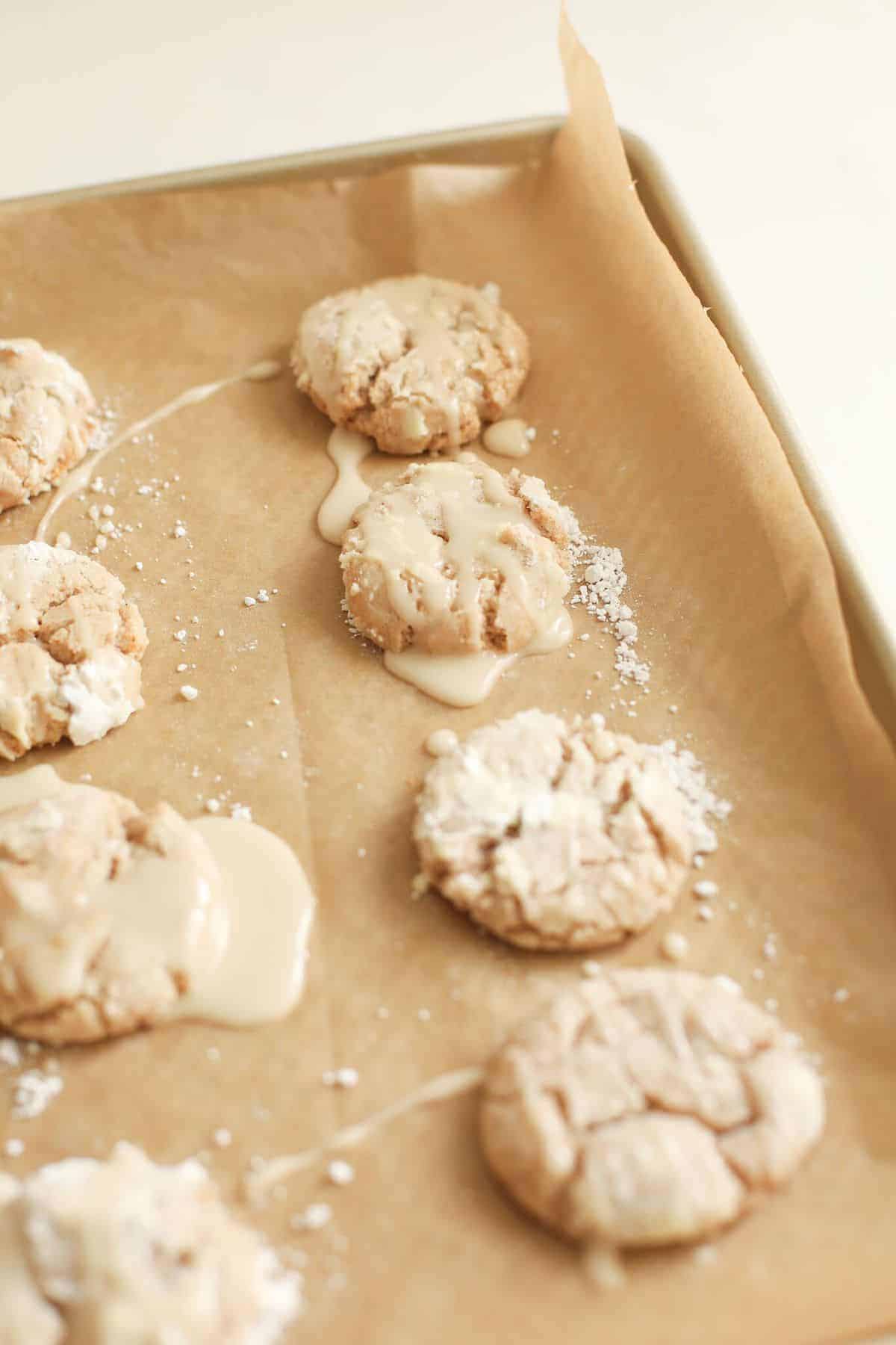 Apple glaze poured over cookies on a gold baking sheet. #appleglaze #appleciderglaze