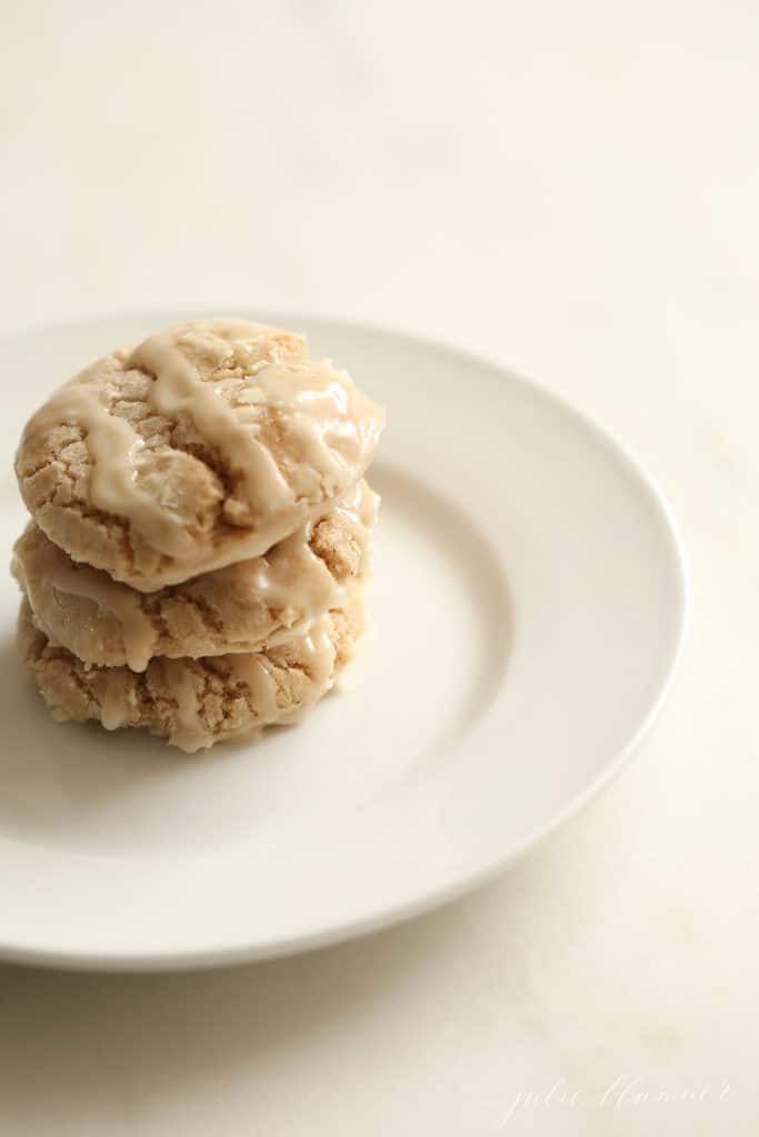 Stack of three apple pie cookies with an apple glaze, on a white plate. #appleglaze #appleciderglaze