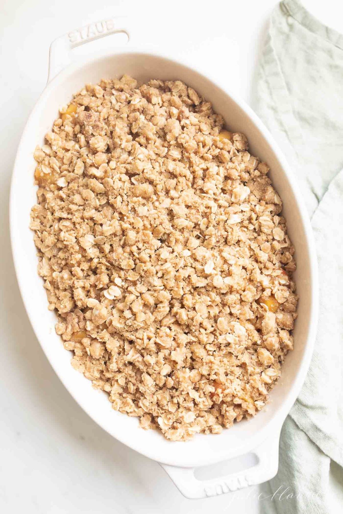 Apple crisp filling in a white oval baking dish