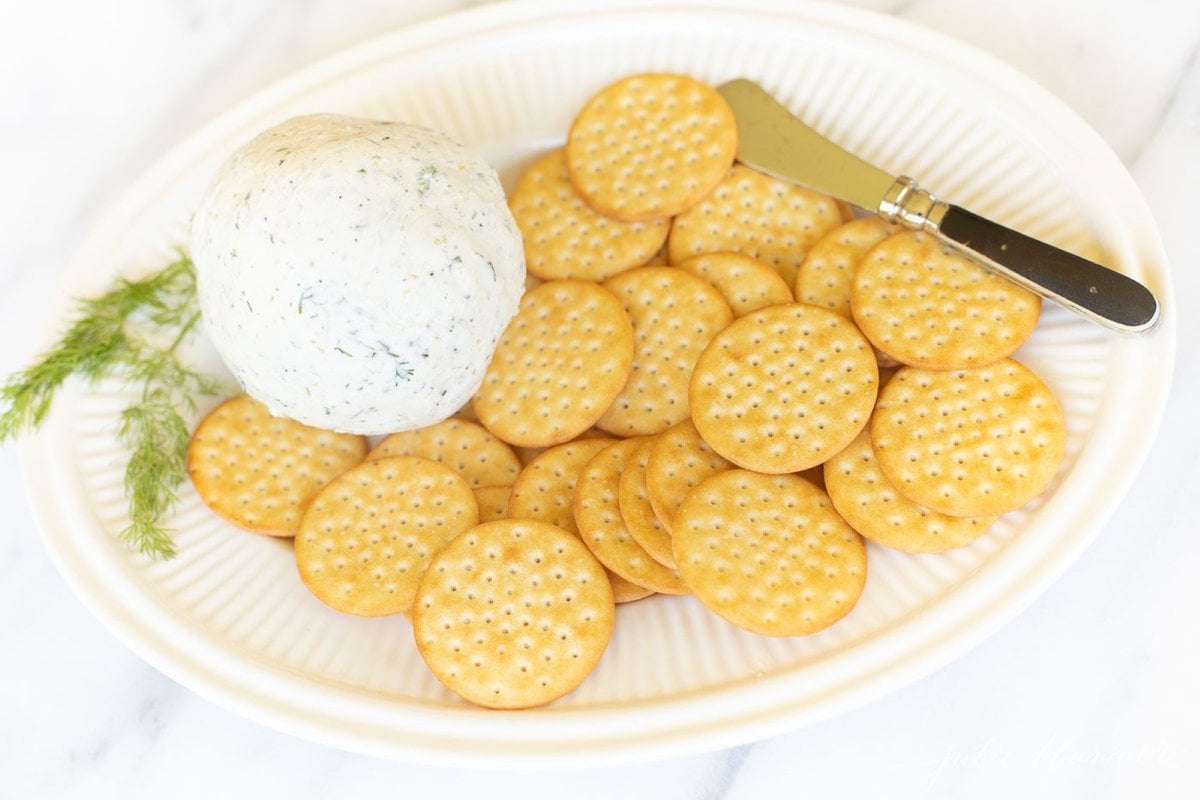 A white plate filled with crackers and homemade Boursin cheese.