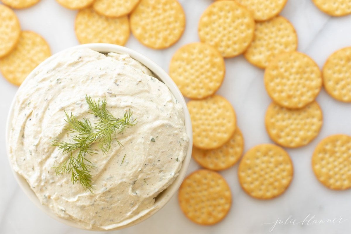 A white plate filled with crackers and homemade Boursin cheese.