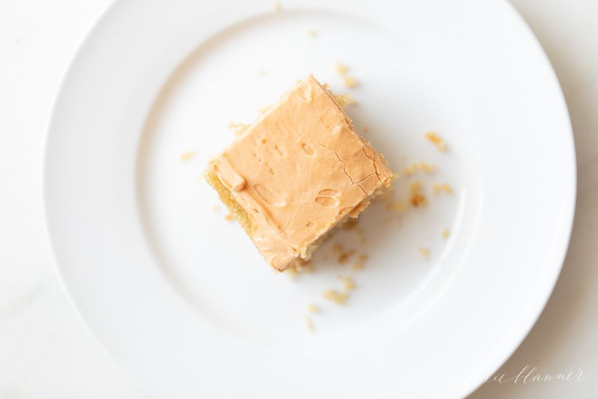 A slice of butterscotch cake on a white plate.