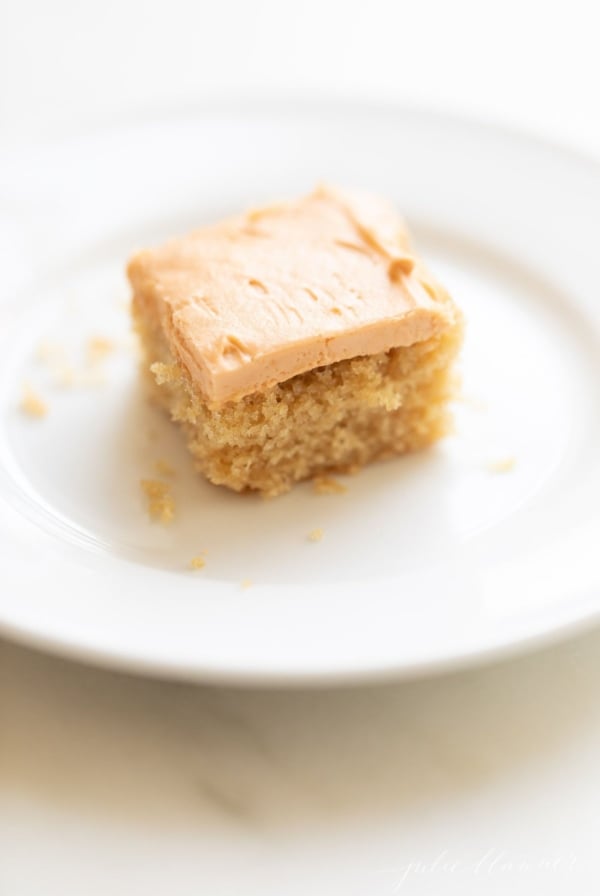 A slice of butterscotch cake on a white plate.