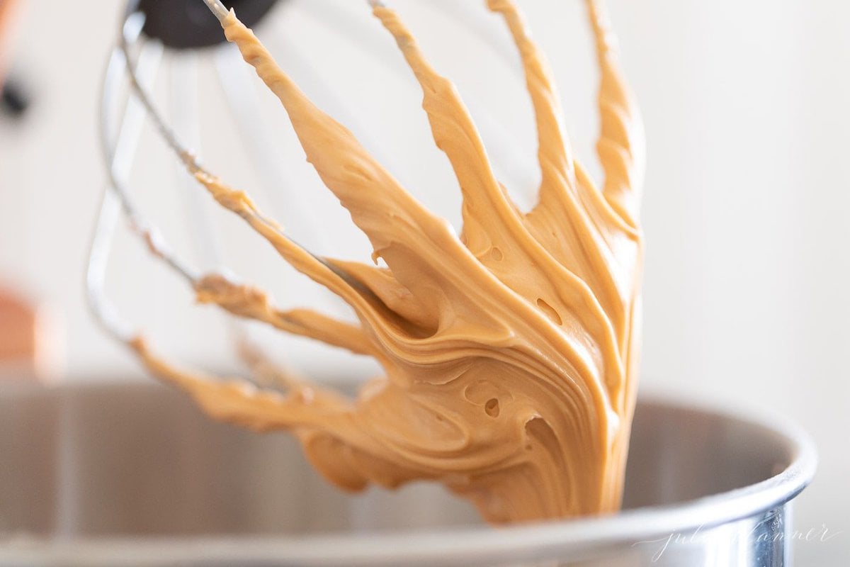 Butterscotch frosting on the whip of a stand mixer.