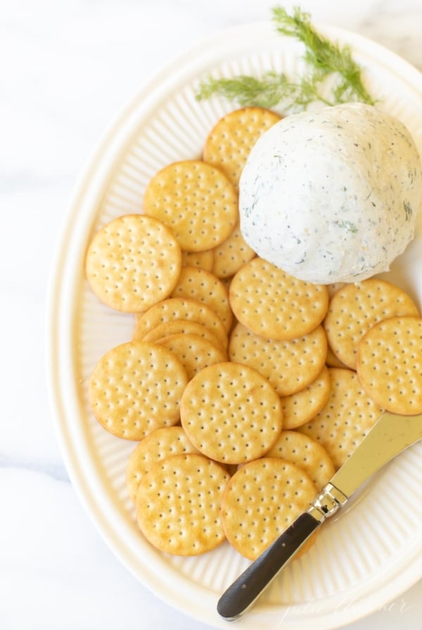 A white plate filled with crackers and homemade Boursin cheese.