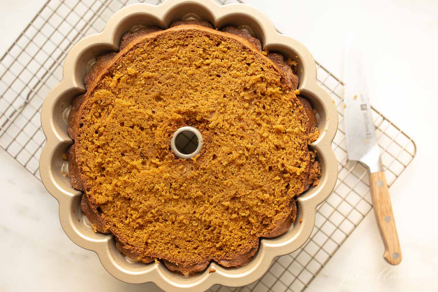 A pumpkin bundt cake on a wire cooling rack.